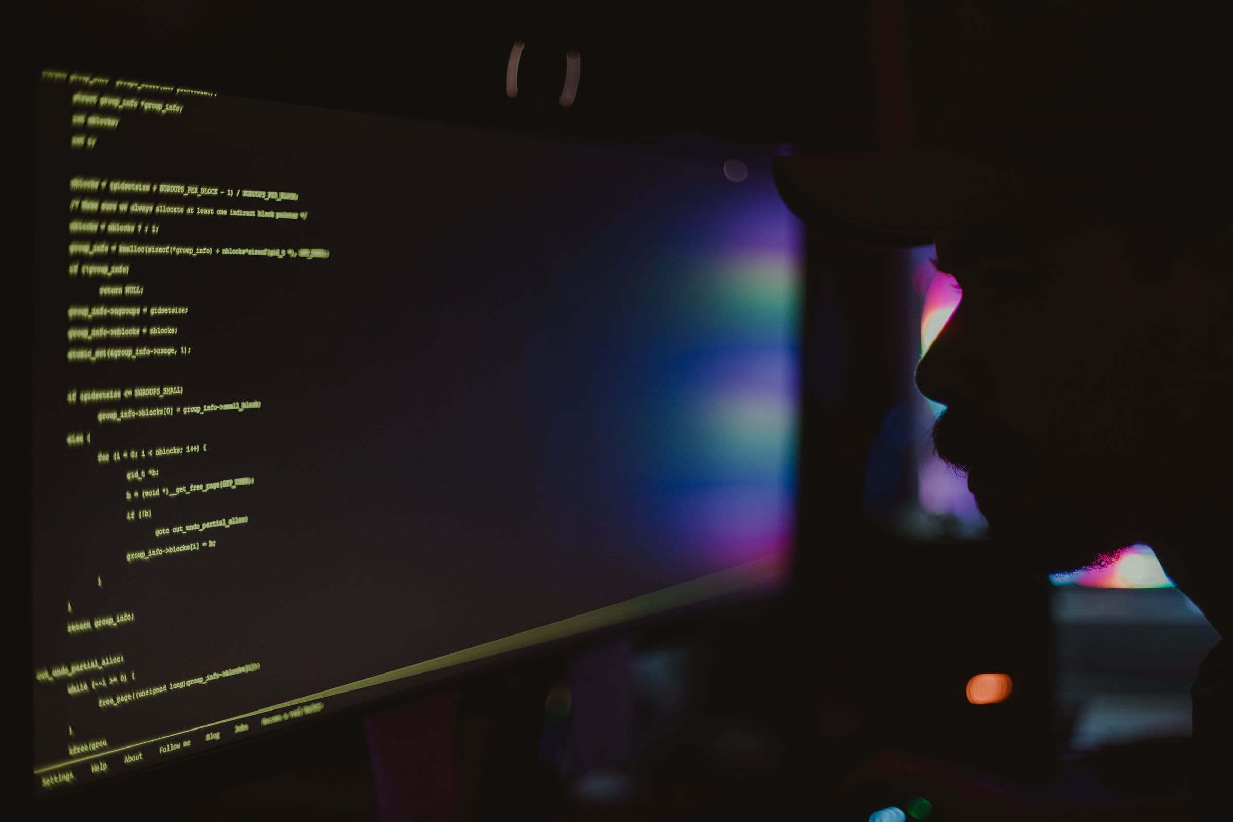 Senior developer working late in a dark, moodily lit office