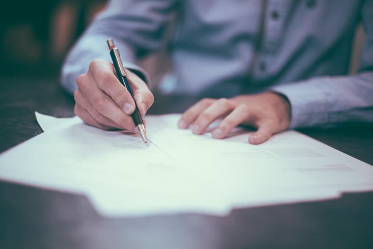Signing a contract by hand at a desk