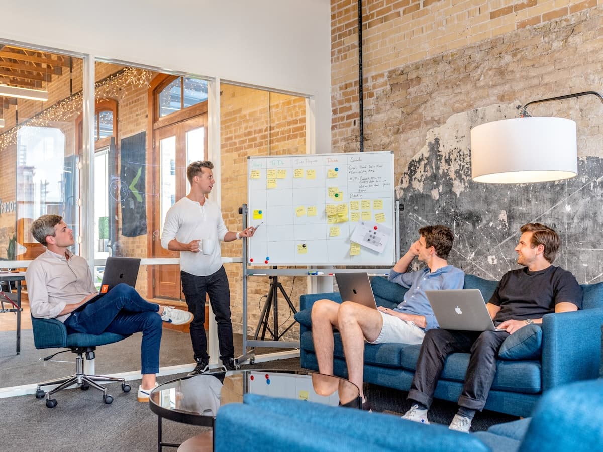 Team planning a sprint at a whiteboard, laptops open